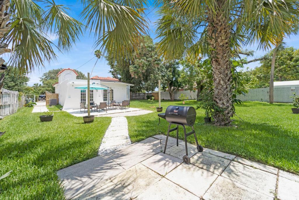 a barbecue in a yard with a palm tree at Heart of West Palm Beach in West Palm Beach
