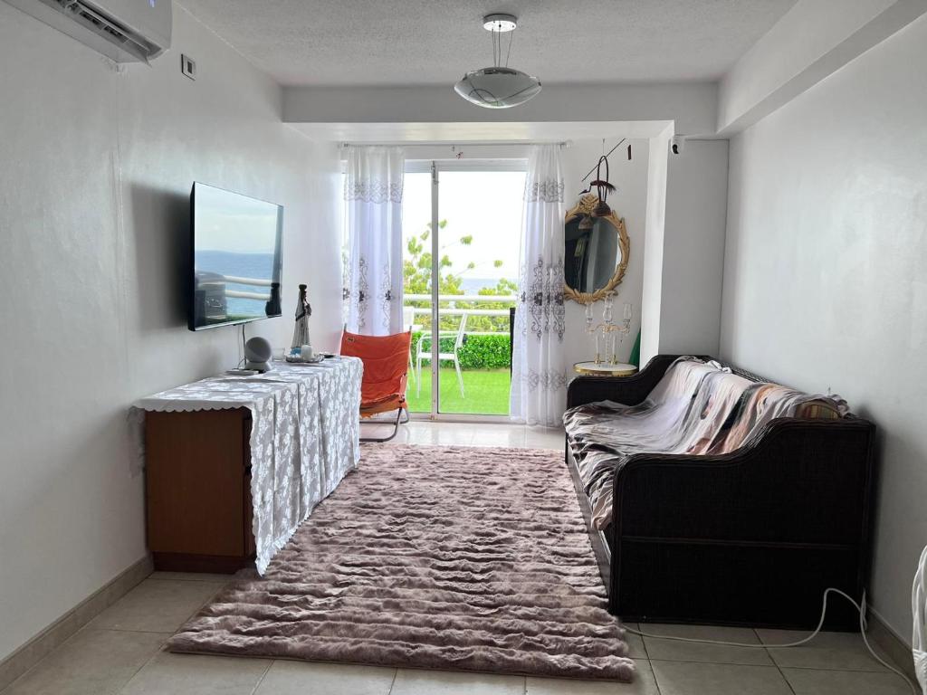 a living room with a couch and a television at Bel appartement sur l'île de Margarita, avec vue sur la mer in Pampatar