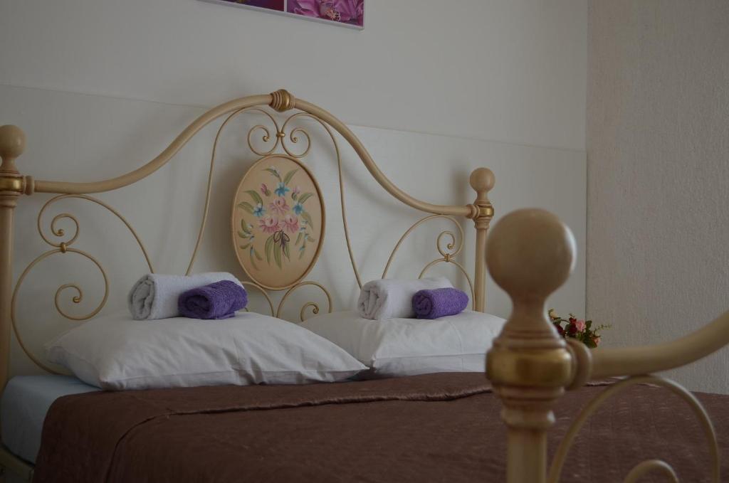 a bed with a white headboard and two pillows at Villa Lanca in Fažana