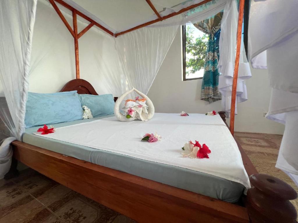 Un dormitorio con una cama con flores. en Mauwa House en Paje