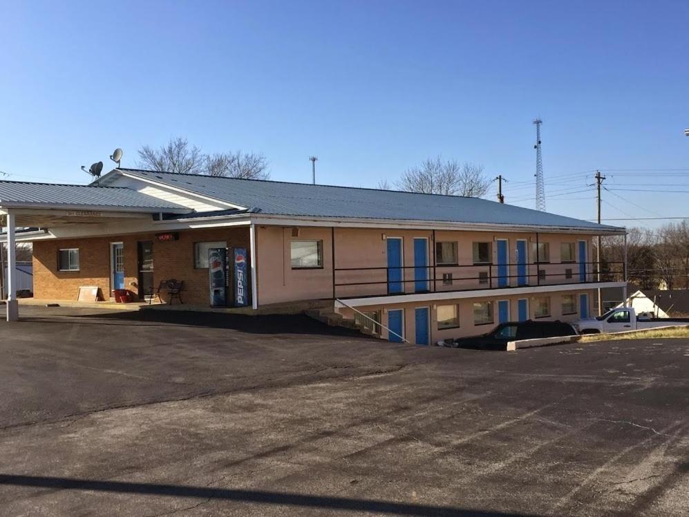 un edificio con puertas azules y aparcamiento en Budget Inn Motel en Bourbon