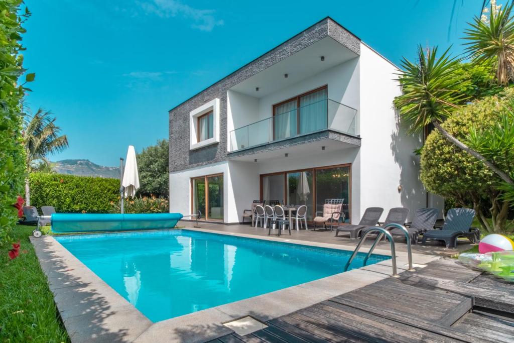 a villa with a swimming pool and a house at Star Villa with private heated pool in funchal in Funchal