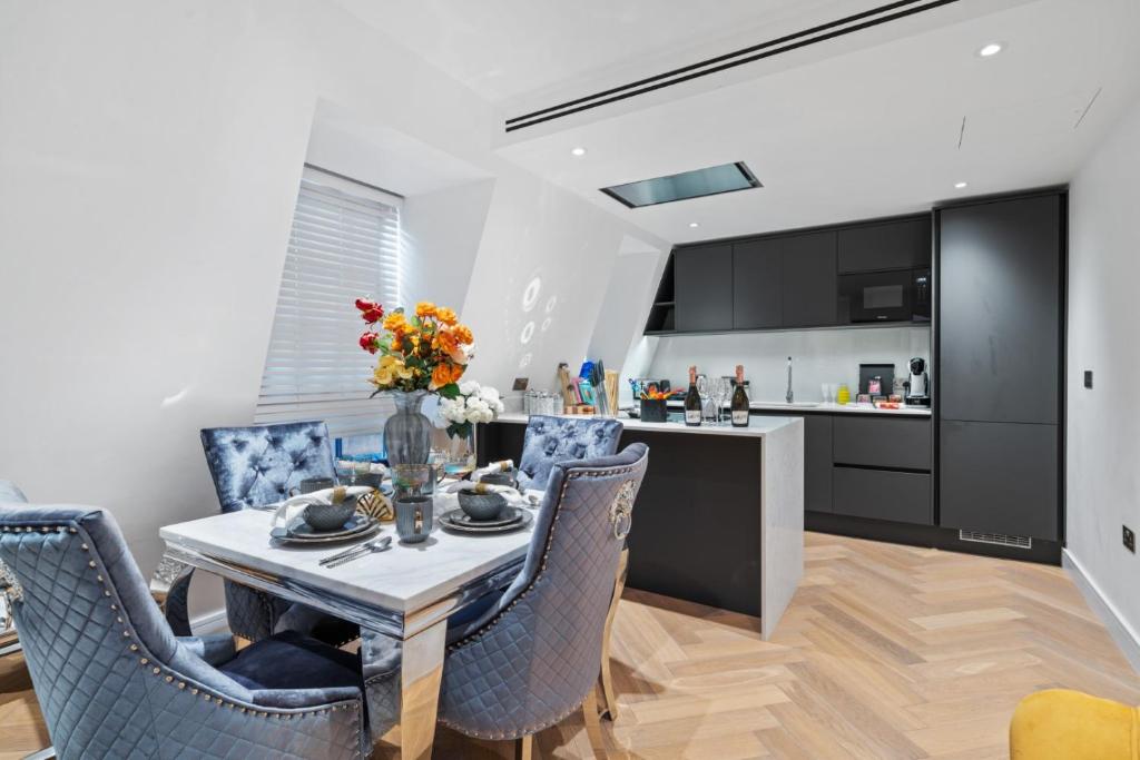 a kitchen and dining room with a table and chairs at Marble Arch Penthouse 1 Bed in London