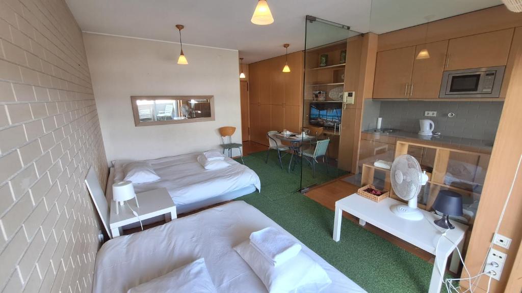 ヴィラ・ノヴァ・デ・ガイアにあるDeluxe Studio in a Great Area by Douro Riverのベッド2台とキッチンが備わる小さな客室です。