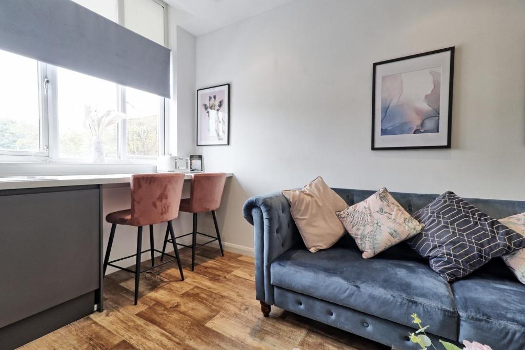 a living room with a blue couch and a counter at Cosy Coastal Haven 1-Bedroom Apartment in Southend-On-Sea - Southend Stays in Southend-on-Sea