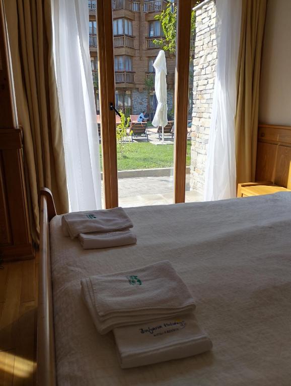 a bedroom with a bed with towels on it at Pirin Golf - NIRVANA, Studio&SPA in Razlog
