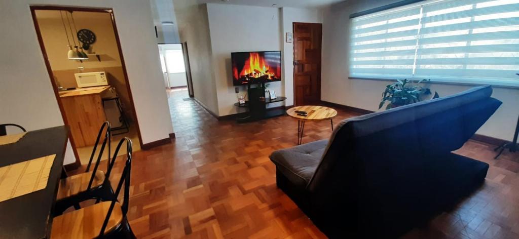 sala de estar con sofá, mesa y chimenea en Acogedor apartamento cerca del teleférico amarillo en La Paz