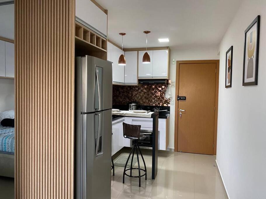 eine Küche mit einem Kühlschrank und einem Tisch darin in der Unterkunft Studio 37 m² Centro Guarulhos in Guarulhos