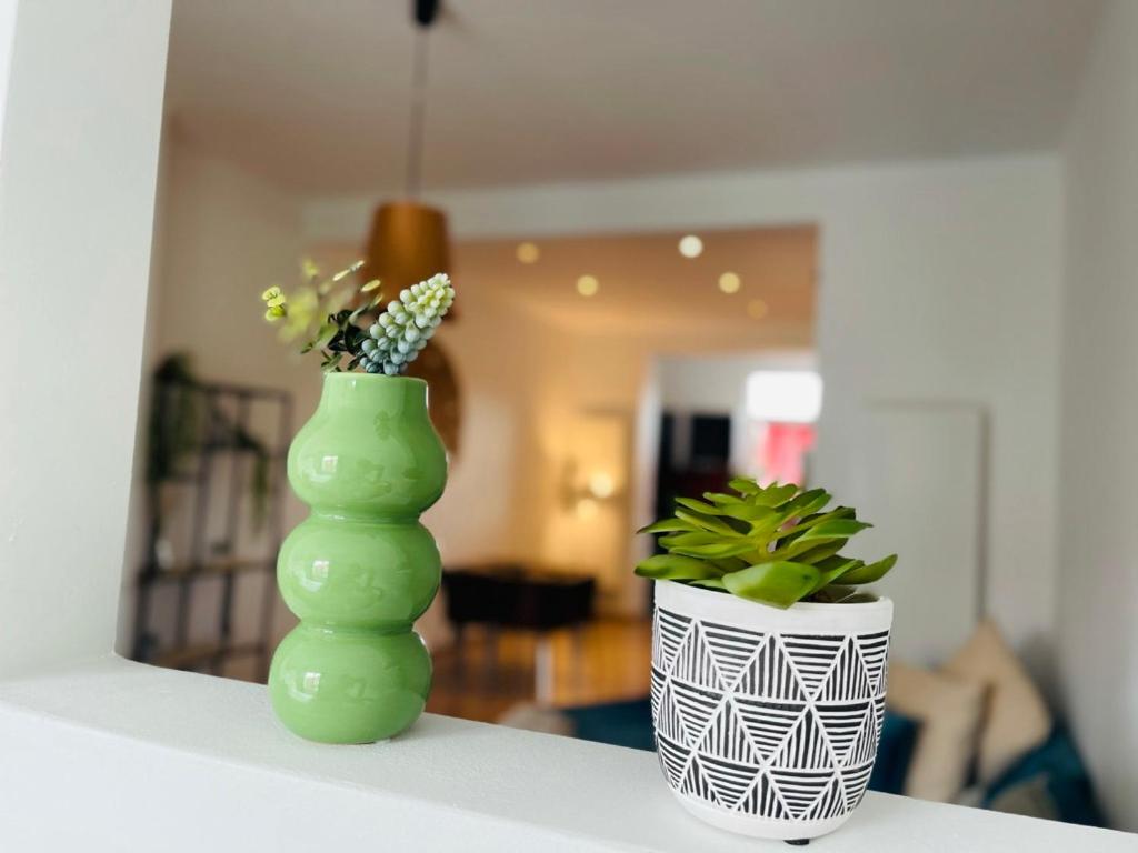 a green vase and a plant on a table at Downtown Quiet and Peacefull Apartment in Brussels