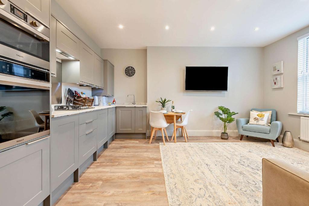 a kitchen with a counter and a table and a tv at Beach Walk Southbourne SOBO Beach Sleeps 4 in Southbourne