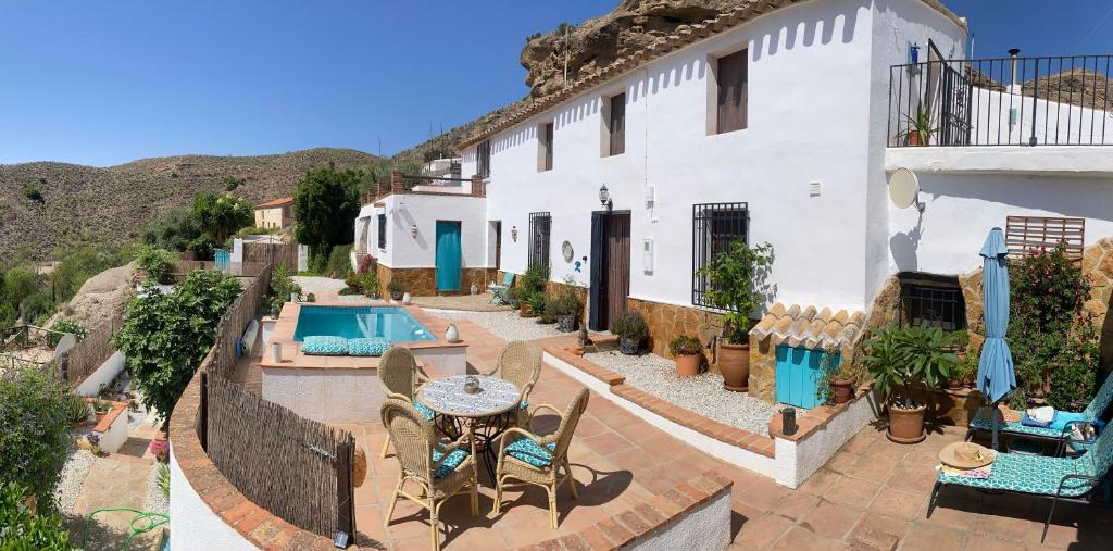 a white house with a patio and a swimming pool at A tranquil mountain escape, casa particular, exclusive accommodation, private pool and terraces in Oria