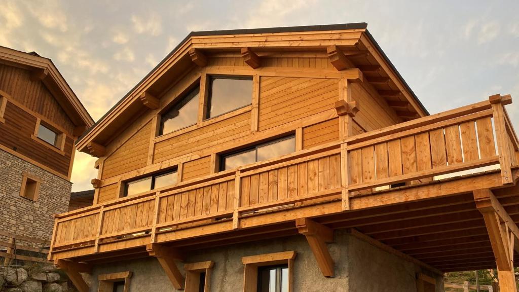 una casa con una terraza de madera encima en Chalet deS'AMY et sa terrasse pour 8/10 personnes, en Font-Romeu-Odeillo-Via