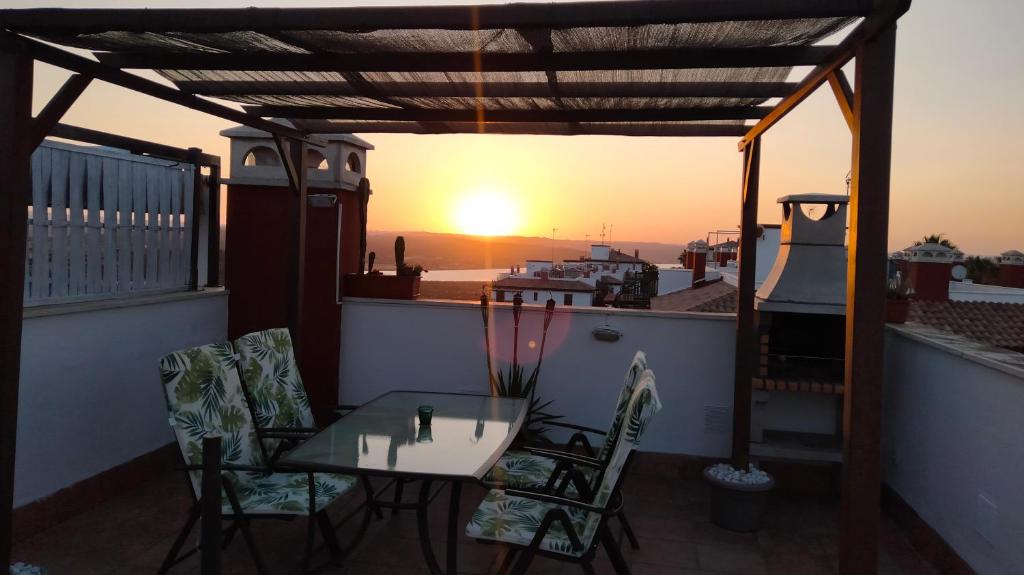 a table and chairs on a balcony with the sunset at La Colina Golf & Beach in Huelva