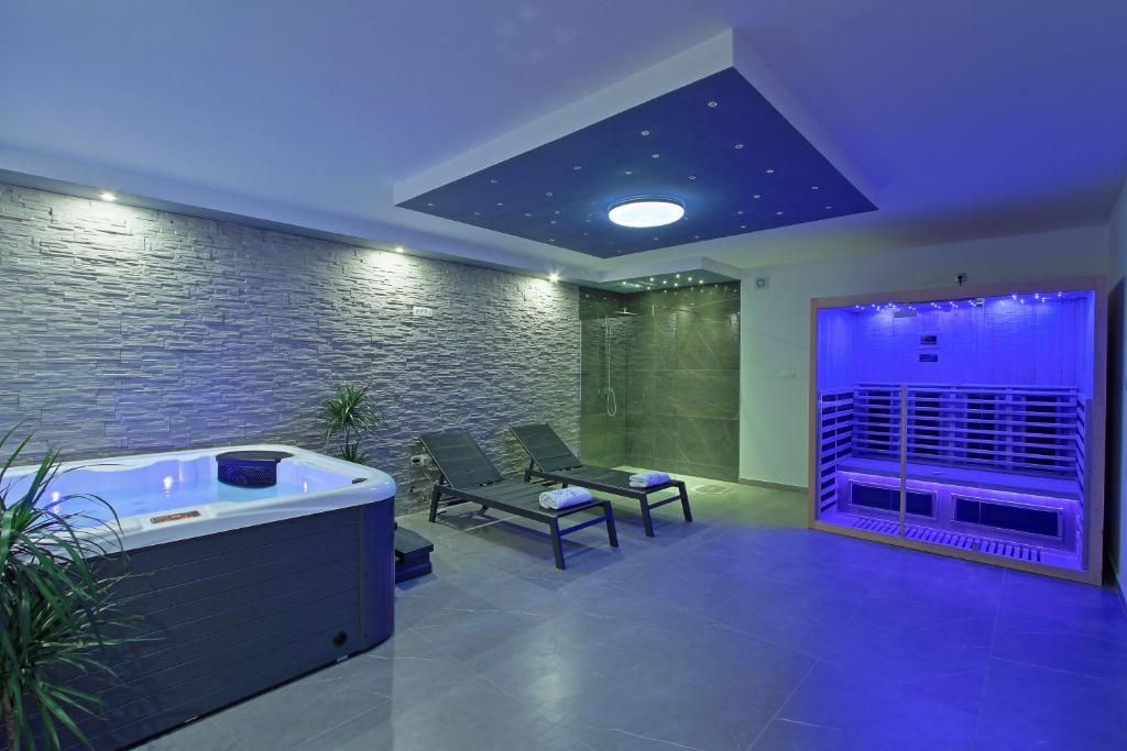 une chambre avec un bain à remous et des chaises dans un bâtiment dans l'établissement Guesthouse L&K SPA, à Brinje