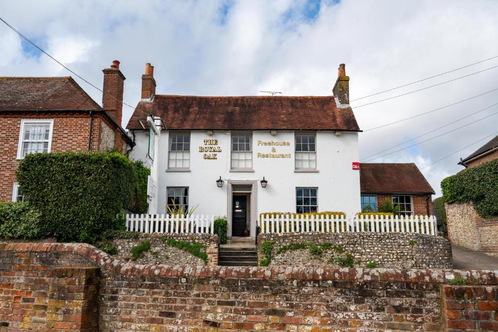 una casa blanca con una valla delante en The Royal Oak Inn, en Chichester