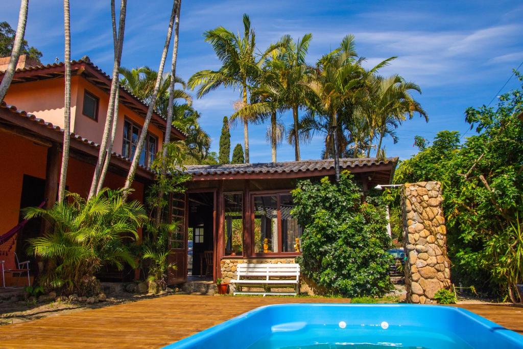 una casa con piscina frente a ella en Pousada Paradise Ferrugem, en Garopaba