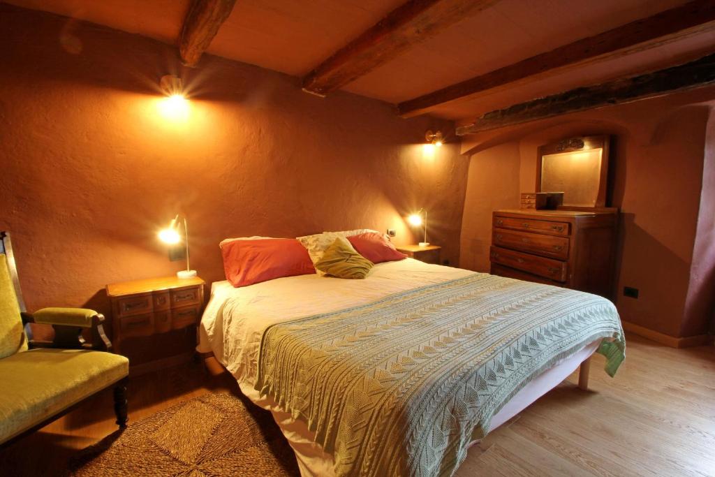 - une chambre avec un lit, une chaise et des lumières dans l'établissement Castelletto, à Giucano