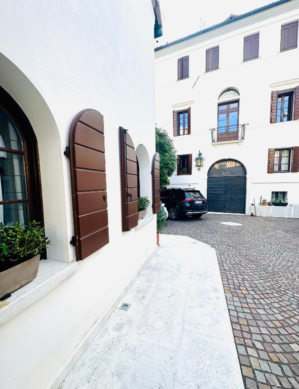a building with brown doors and a brick street at Ca' Degli Uberti Dimora Storica in Treviso