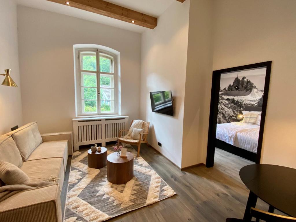 un soggiorno con divano e letto di ciao-aschau Haus zur Burg FeWo Bergfest Ap110 a Aschau