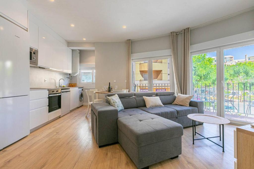 uma sala de estar com um sofá cinzento e uma cozinha em Central Torremolinos Apartment em Torremolinos