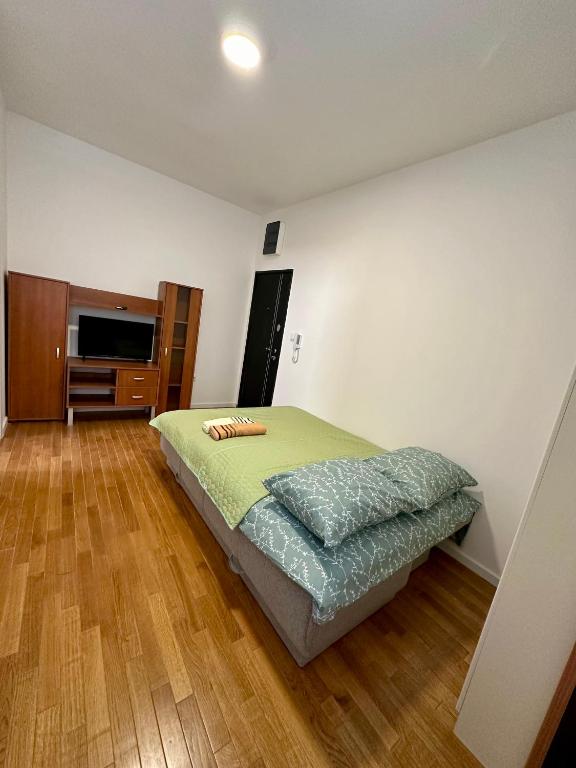 a bedroom with a bed and a flat screen tv at Apartment Stex 2 in Podgorica