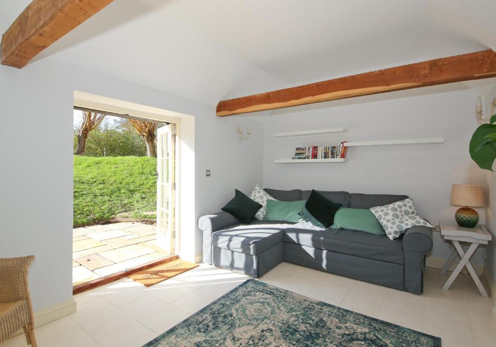 a living room with a couch and a window at The Lavendrye in Wadhurst