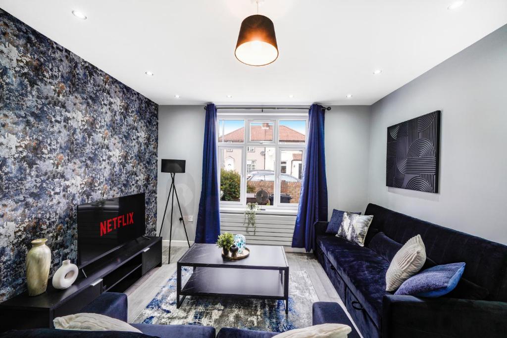 a living room with a blue couch and a tv at Exquisite London Home - Parking - Sleeps 10 in Dagenham