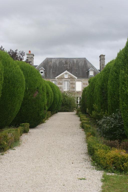 un chemin menant à une maison avec des buissons dans l'établissement Les Sapins, à Beaumesnil