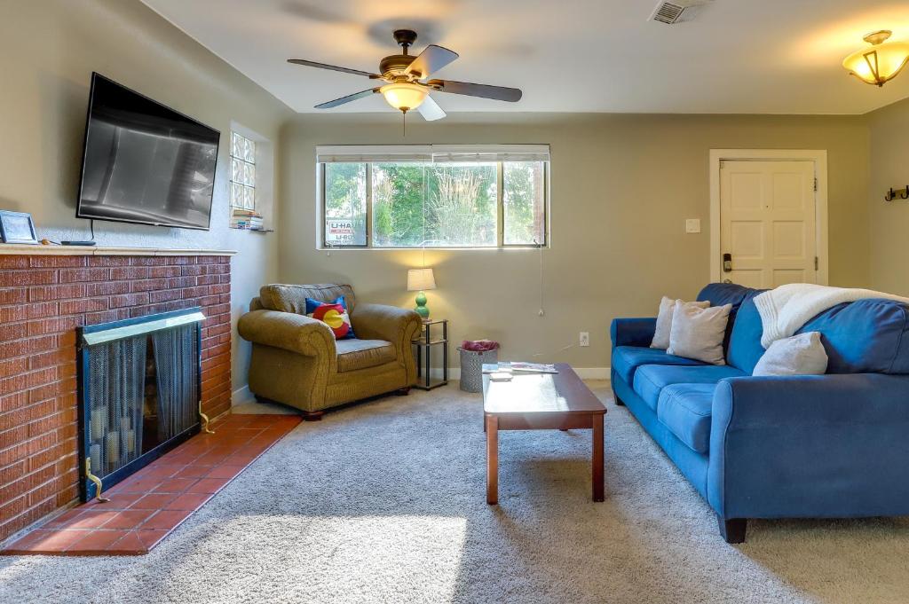 a living room with a blue couch and a fireplace at Denver Vacation Rental Near Parks and Attractions! in Denver