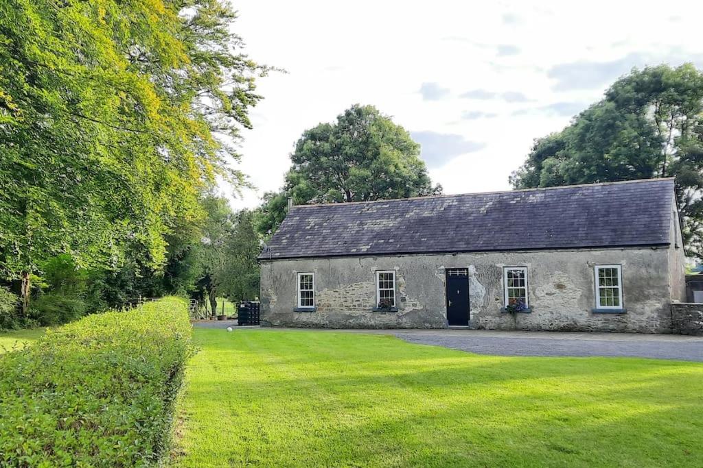una vecchia casa in pietra con un ampio cortile di Dundonagh House, Glaslough, a Monaghan