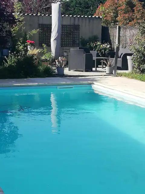 a swimming pool with blue water in a yard at Chambre in Montech