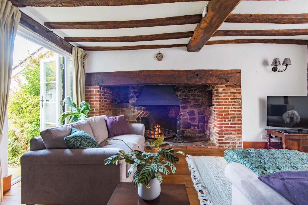西馬靈的住宿－Farriers Cottage by Bloom Stays，带沙发和壁炉的客厅
