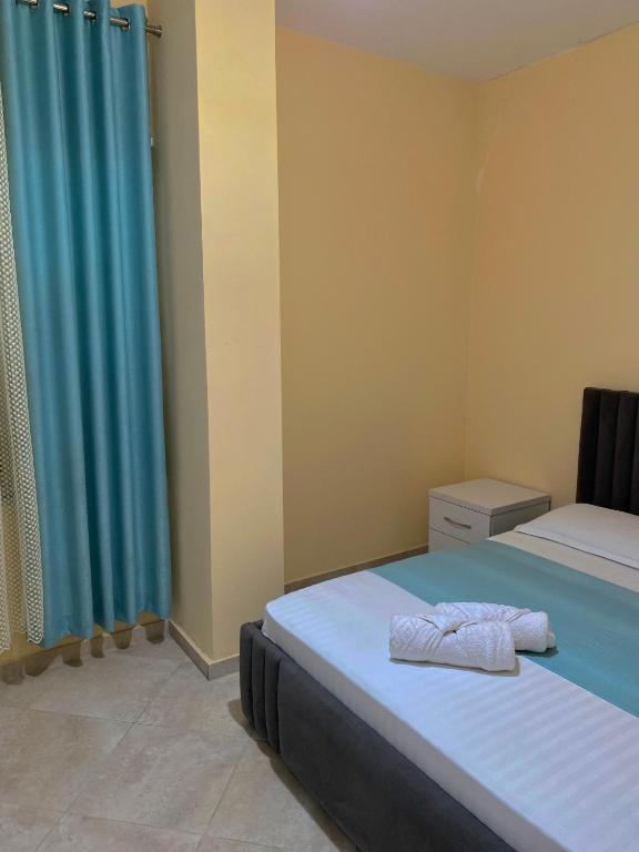 ein Schlafzimmer mit 2 Betten und einem blauen Vorhang in der Unterkunft Durres Apartament Sea View in Durrës