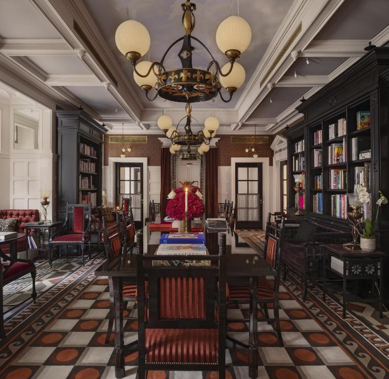 a dining room with tables and chairs and a chandelier at At Sloane in London