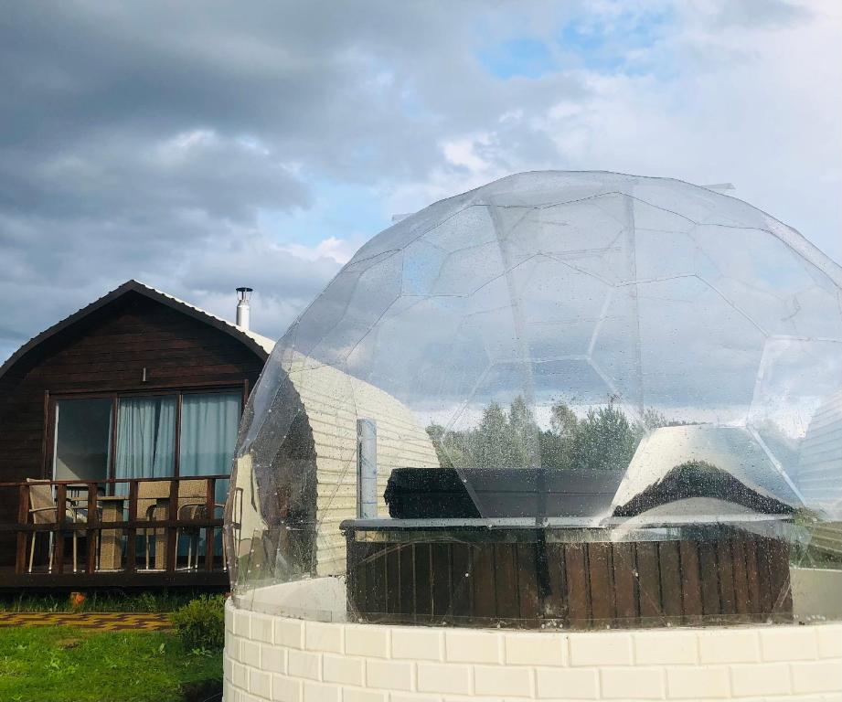 un edificio con una cúpula de cristal junto a una casa en Viesu māja Virši, en Stropi