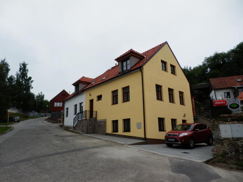 una casa amarilla con un coche rojo aparcado delante de ella en Dueta Apartment, en Český Krumlov