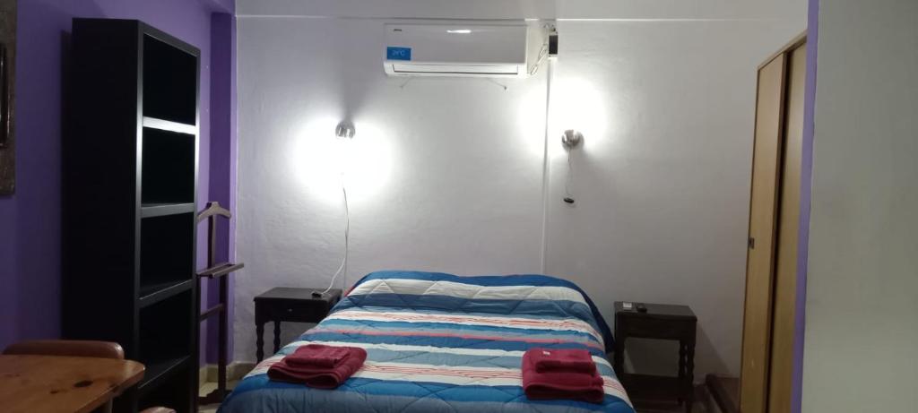 um pequeno quarto com uma cama e ar condicionado em Tacita de Plata Apart em San Salvador de Jujuy