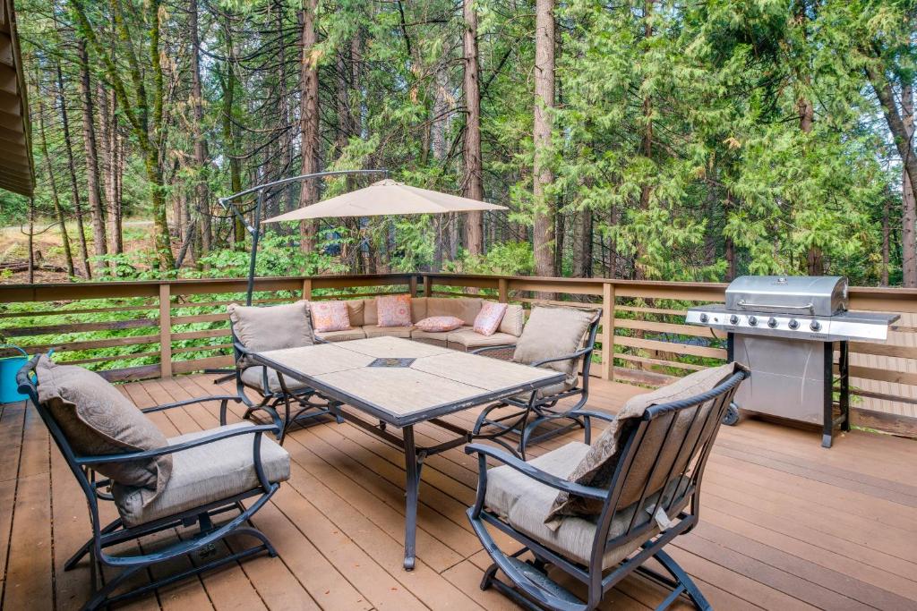 um pátio com uma mesa, cadeiras e comodidades para churrascos em Secluded Arnold Vacation Rental Cabin with Game Room em Arnold
