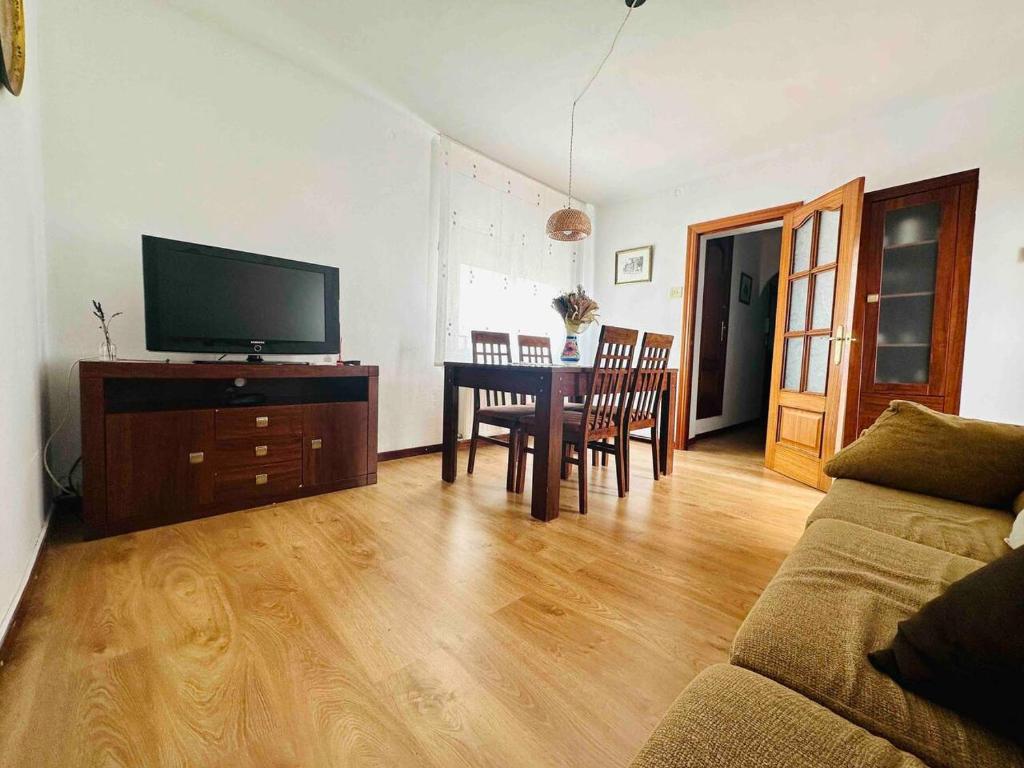 a living room with a couch and a table with a television at Cal Boix Apartamento in Tremp