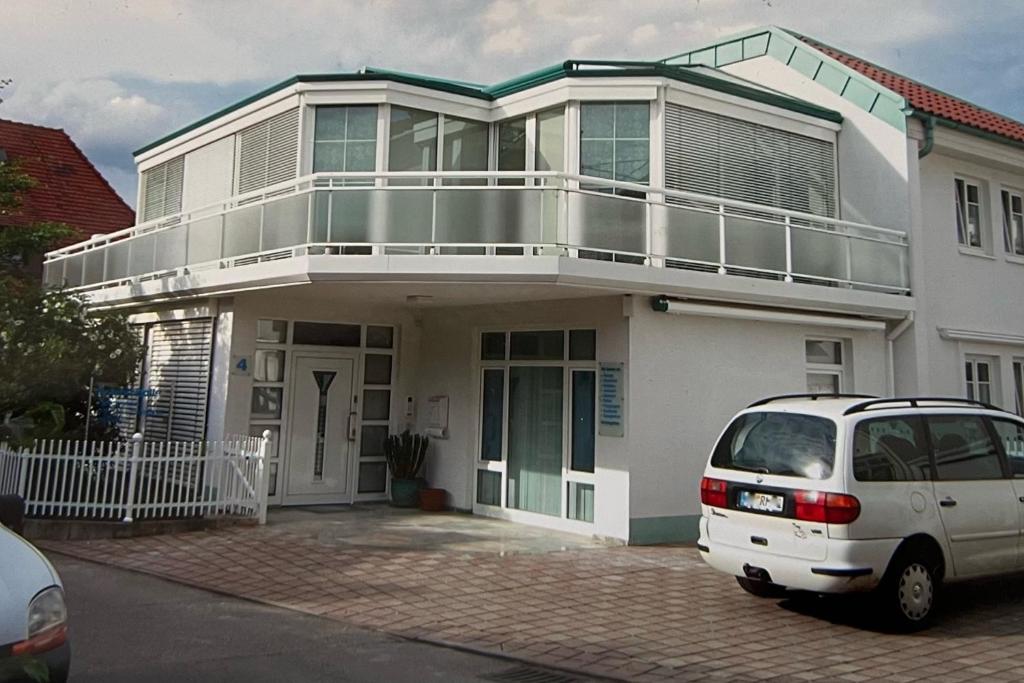 una furgoneta blanca estacionada frente a una casa blanca en Gästehaus3land in Weil am Rhein, en Weil am Rhein