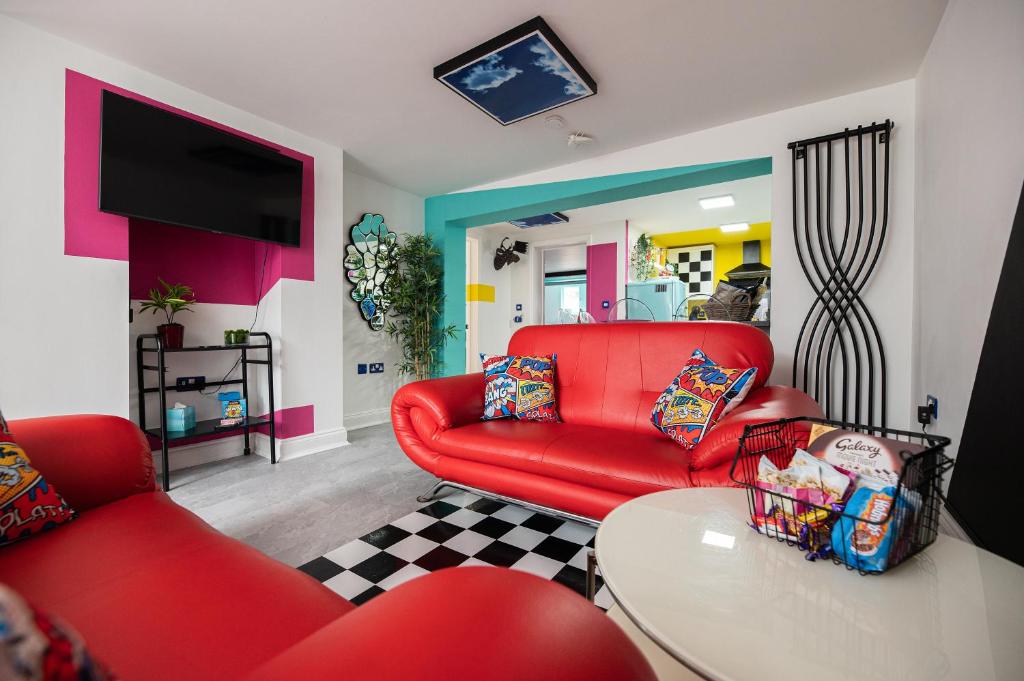 sala de estar con sofá rojo y mesa en Flawsome stays colourful Whimsical Apartment with Garden close to Ramsgate Harbour great for families, en Ramsgate
