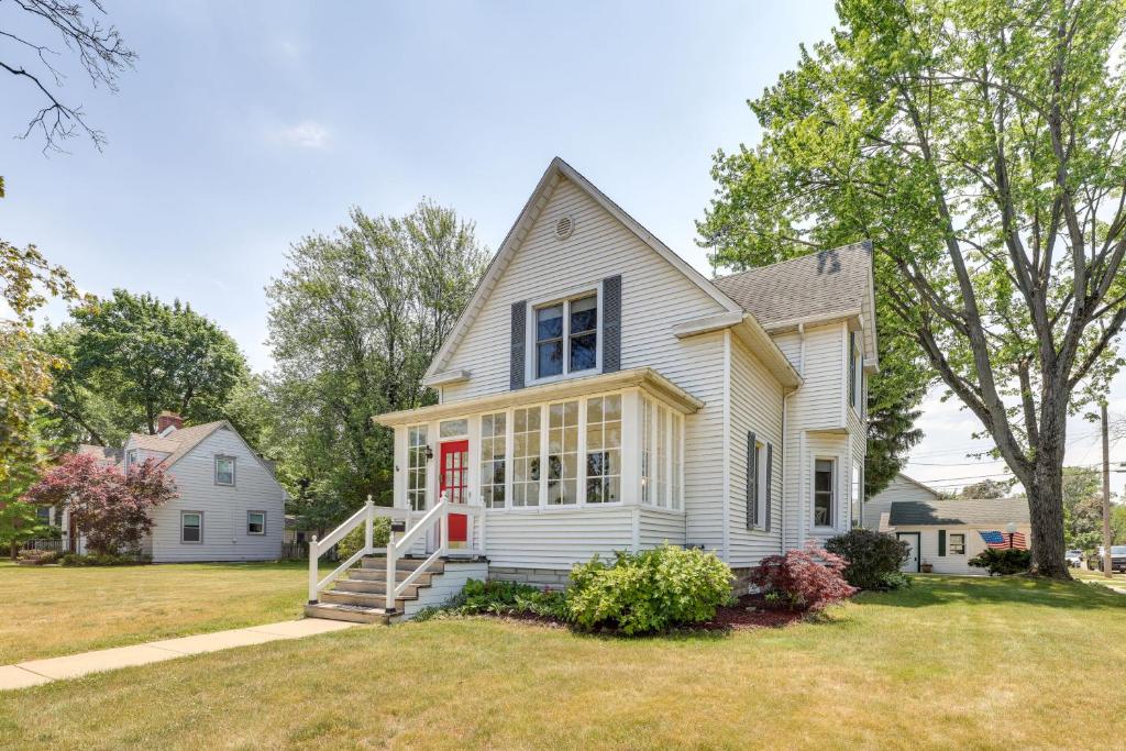 ein weißes Haus mit einer roten Tür in der Unterkunft Charming Chesterton Home with Idyllic Location! in Chesterton