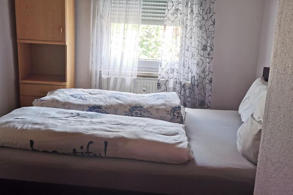 two beds in a room with a window at Maison Room in Karlsruhe
