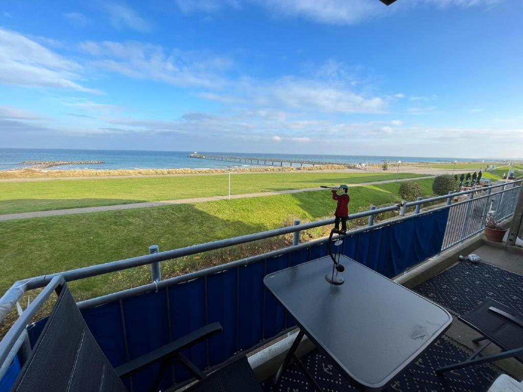 een persoon op een tafel op een balkon met het strand bij Strandkieker in Schönberger Strand