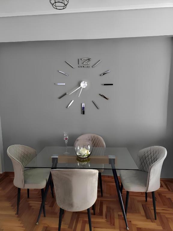a dining room with a table and a clock on the wall at Εlite Αpartment Trikala in Tríkala