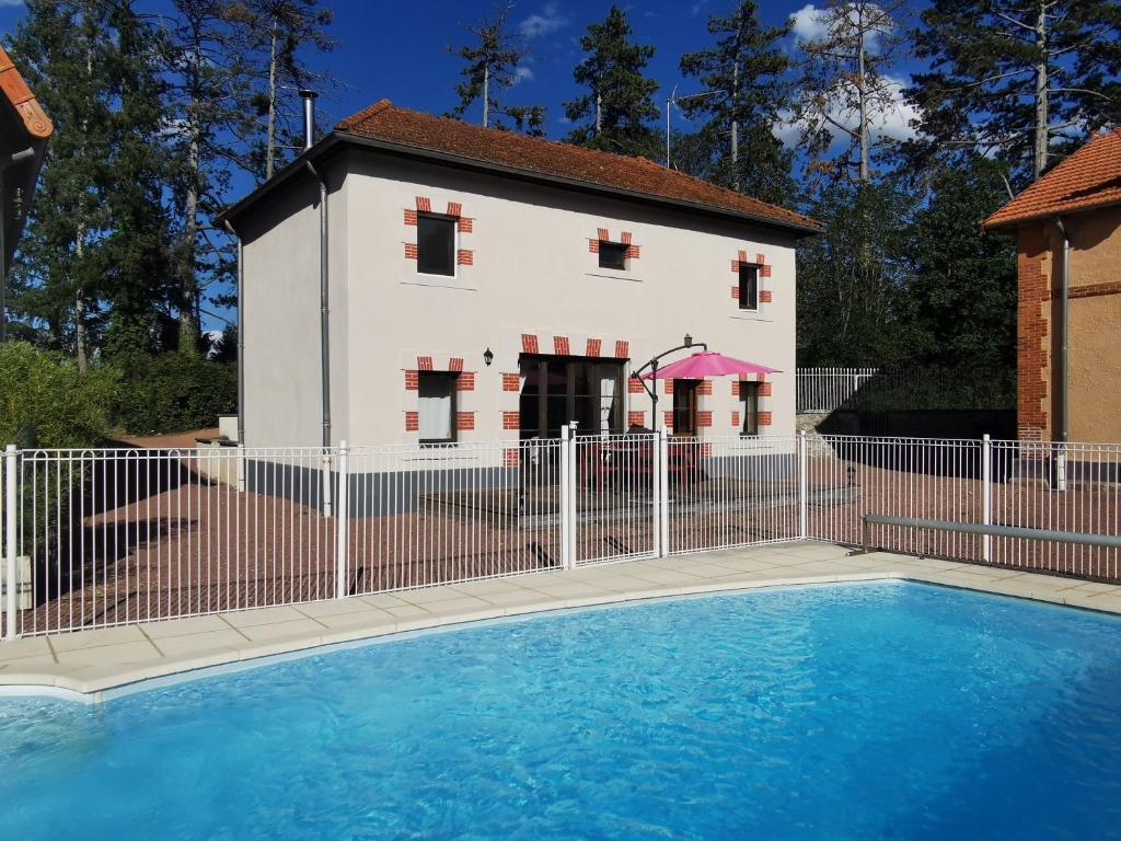een huis en een zwembad voor een hek bij Cottage Trève Raisin in Perreux