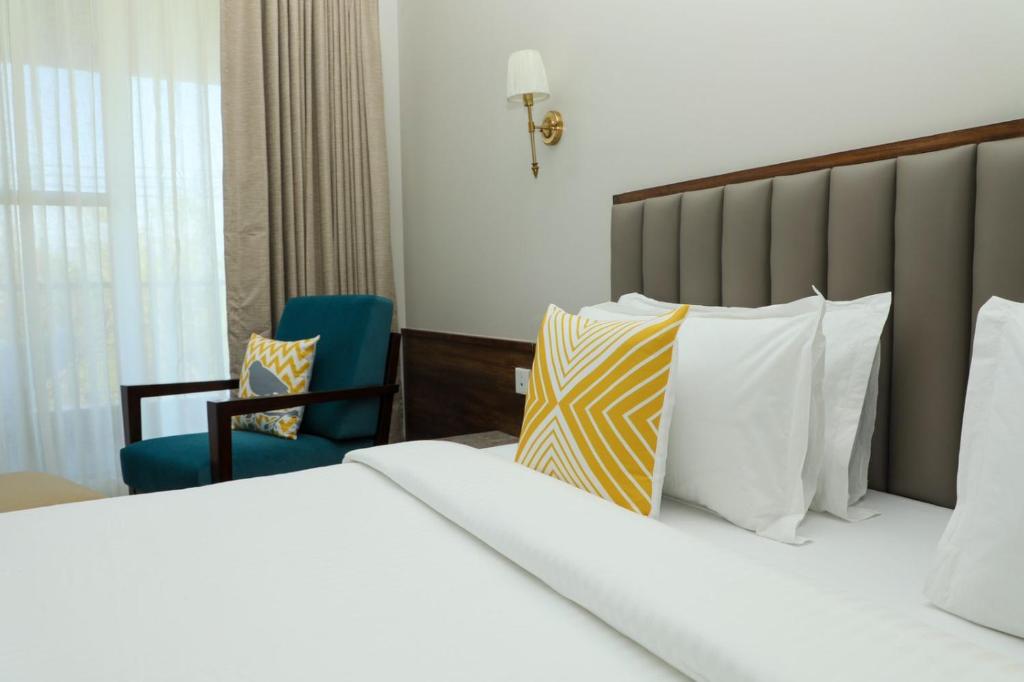 a hotel room with a bed and a chair at Golden Fields Resort in Mulshi