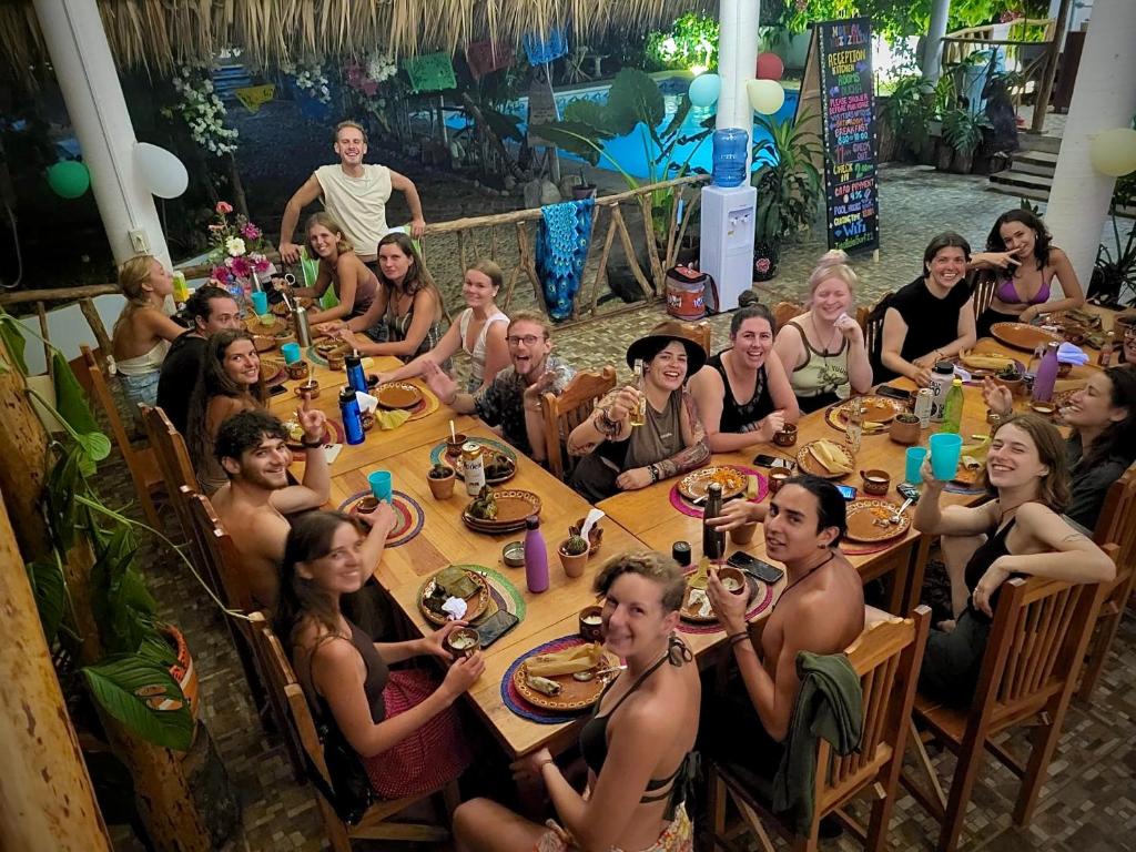 Un gruppo di persone sedute a tavola che mangiano di Huitzilin Hostal a Brisas de Zicatela