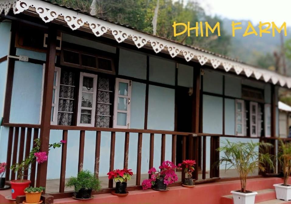 a building with potted plants on a balcony at Dhim Farmstay in Namchi