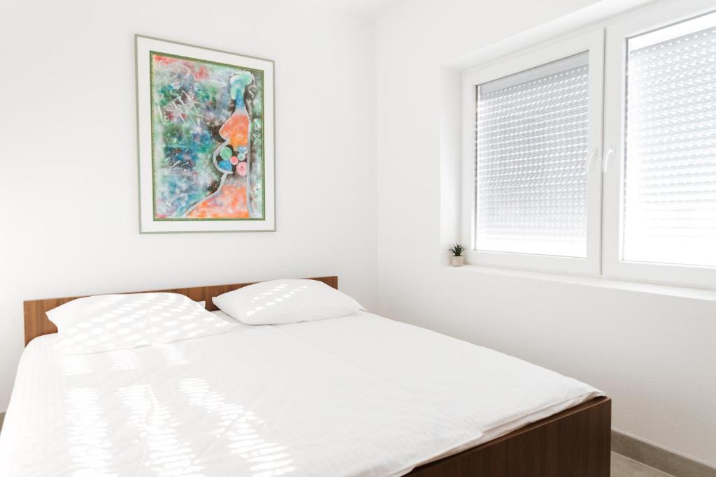 - une chambre blanche avec un lit et une fenêtre dans l'établissement Villa Mia, à Prnjavor